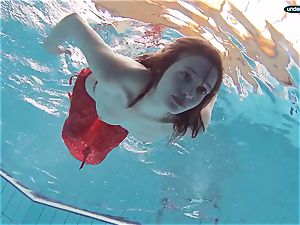 crimson dressed teenager swimming with her eyes opened